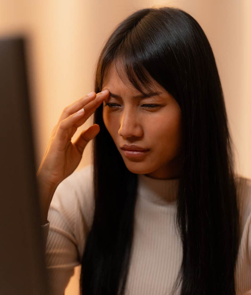 person at computer touches forehead showing job is making them sick