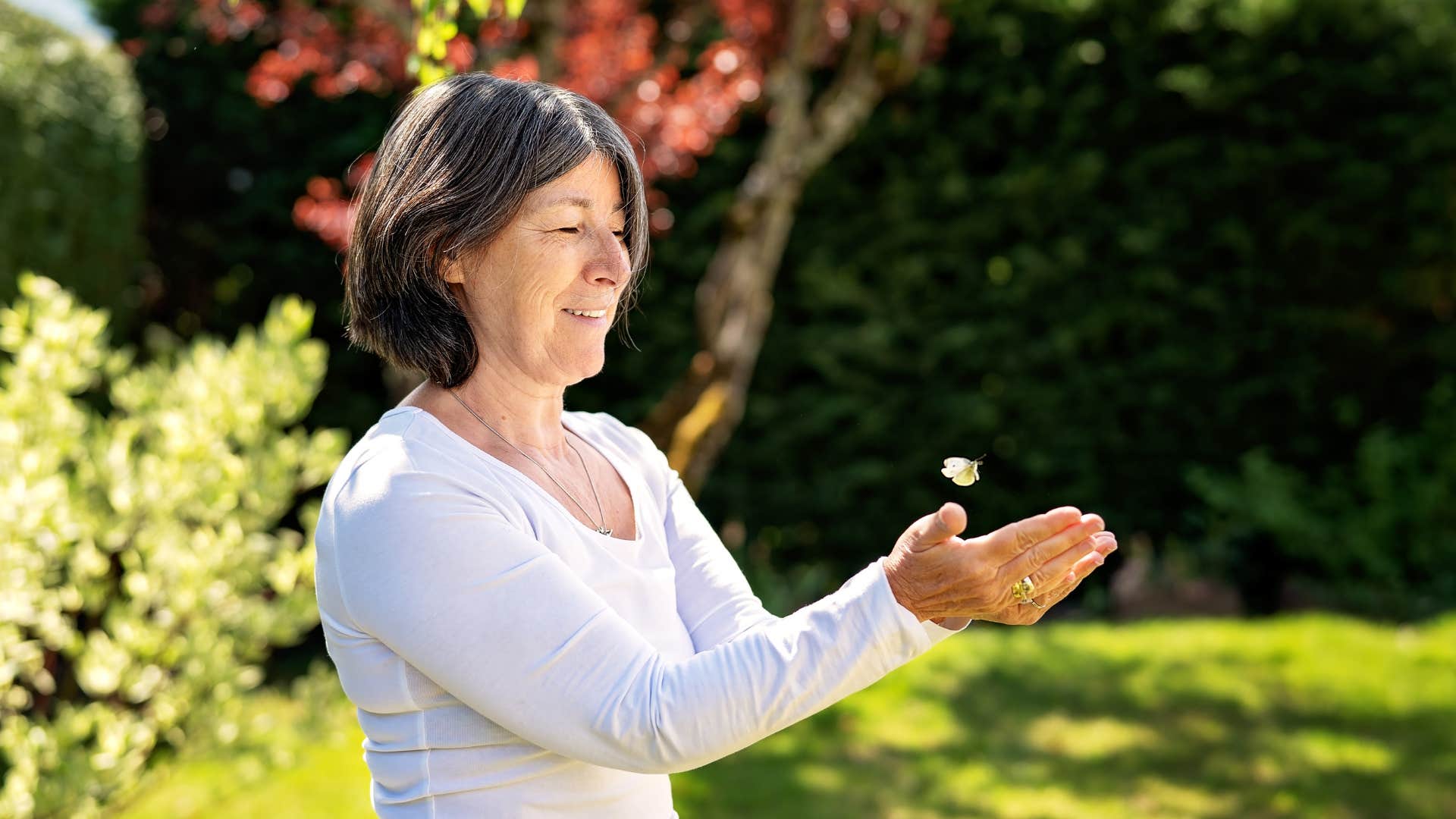 aging person catches butterfly in hand showing lightheartedness