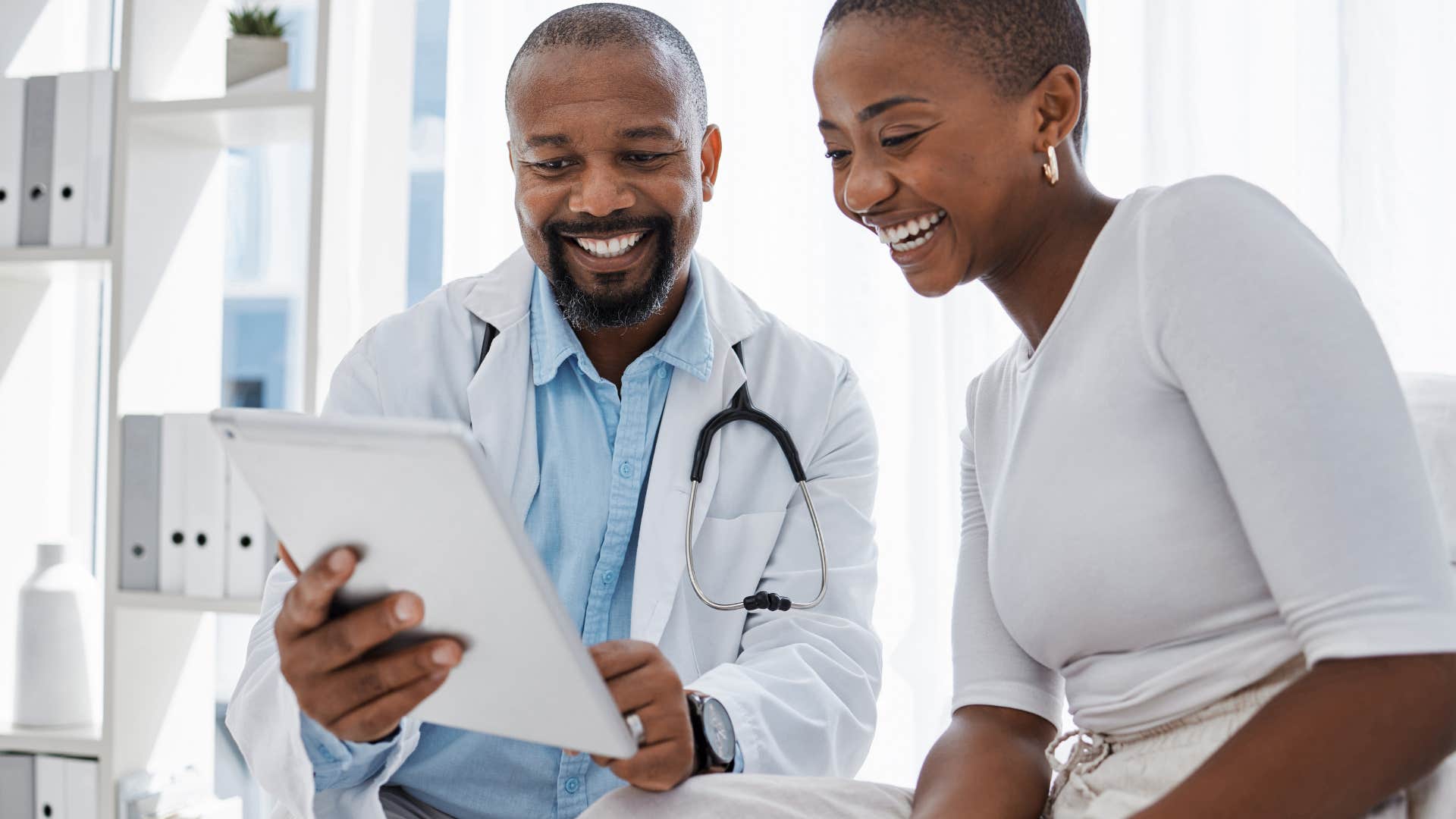 smiling doctor showing woman results on chart