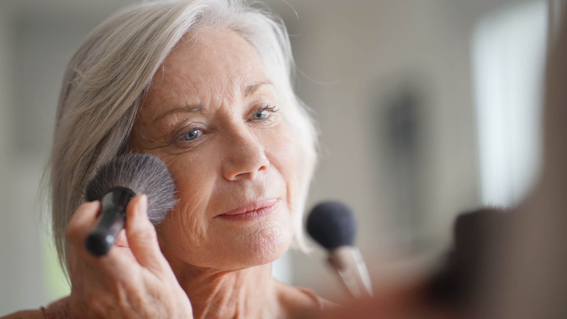 older person applies makeup showing getting over youth