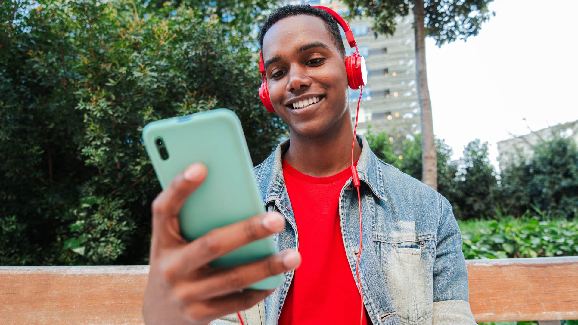 gen z man wearing headphones comparing himself to others on social media