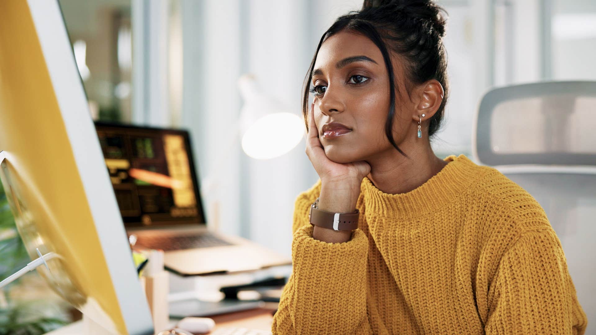 woman finding it difficult to sit with boredom at her desk