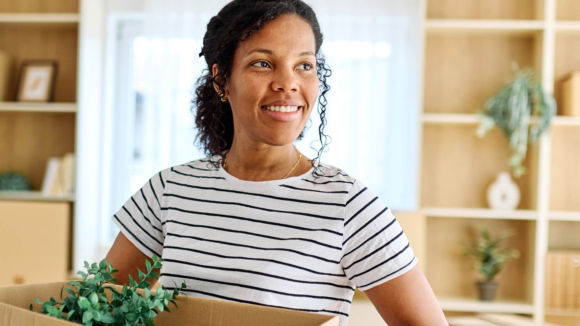 woman moving out holding cardboard box