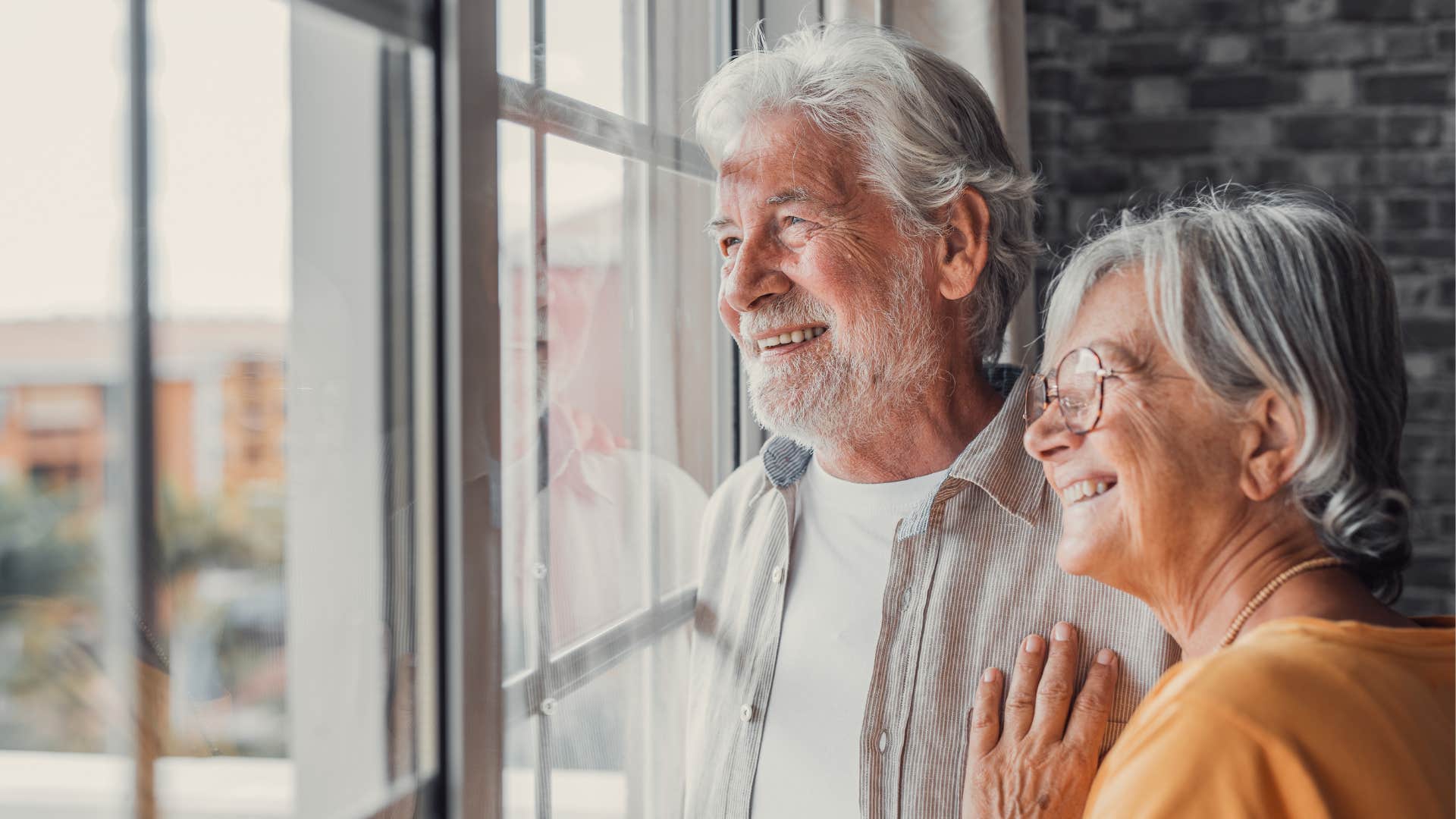 Exited couple look out window showing happy relationship