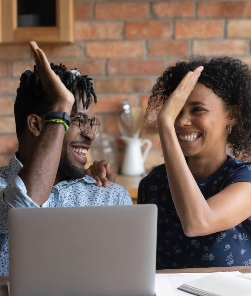 Happy couple high five showing they got their finances together