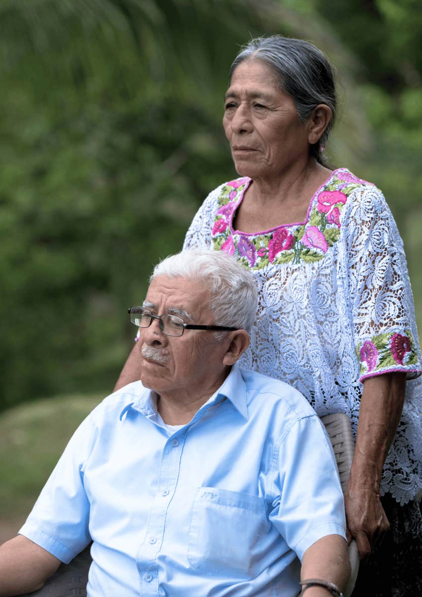 serious older couple sitting outside together