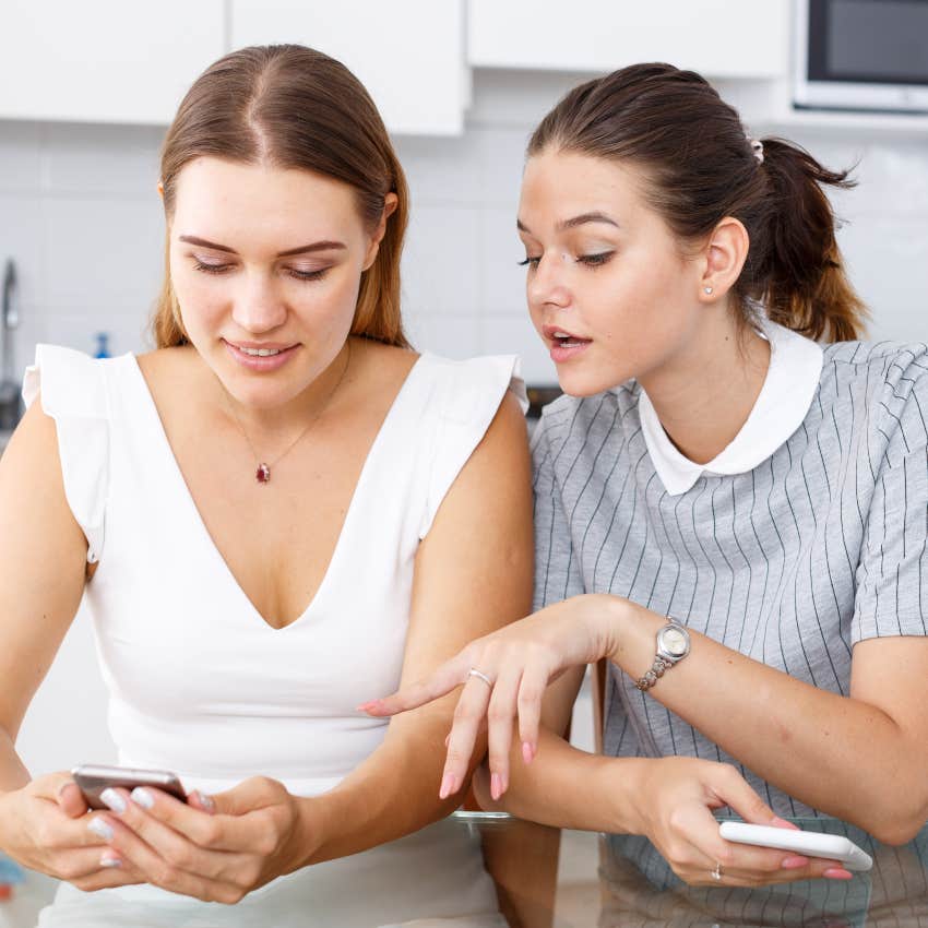 woman showing friend picture of her outfit