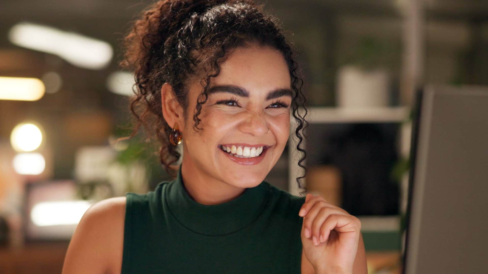 Woman who doesn't need to prove their worthiness smiling at work.