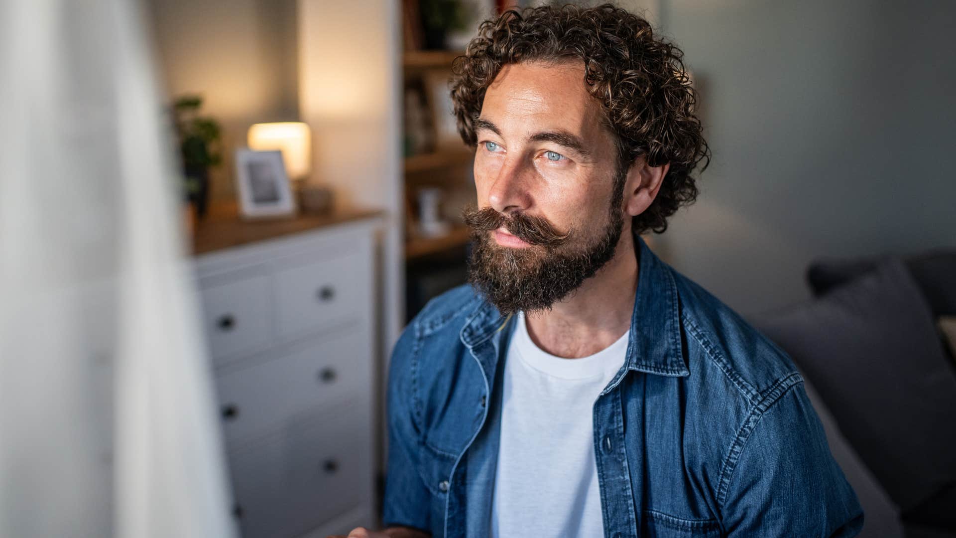 Man who appreciates alone time and craves connection sitting at home.