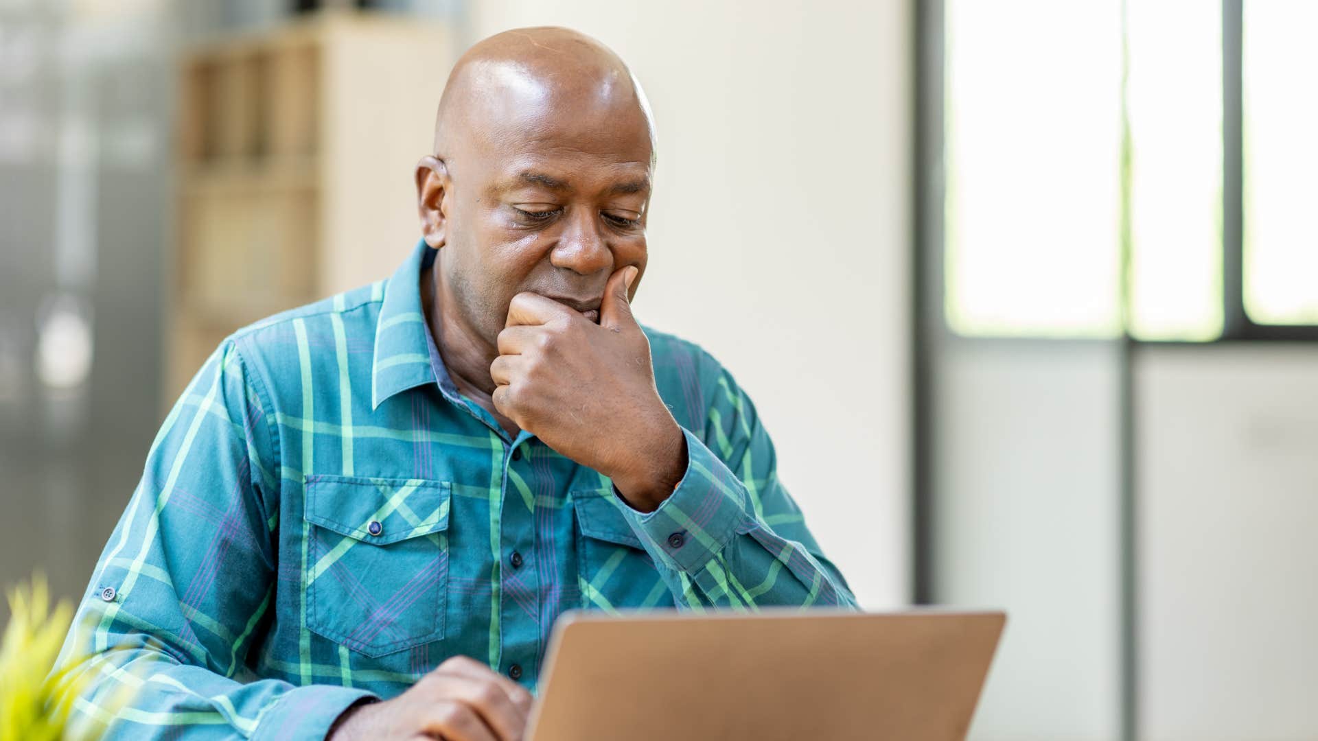 older person with laptop works on goal