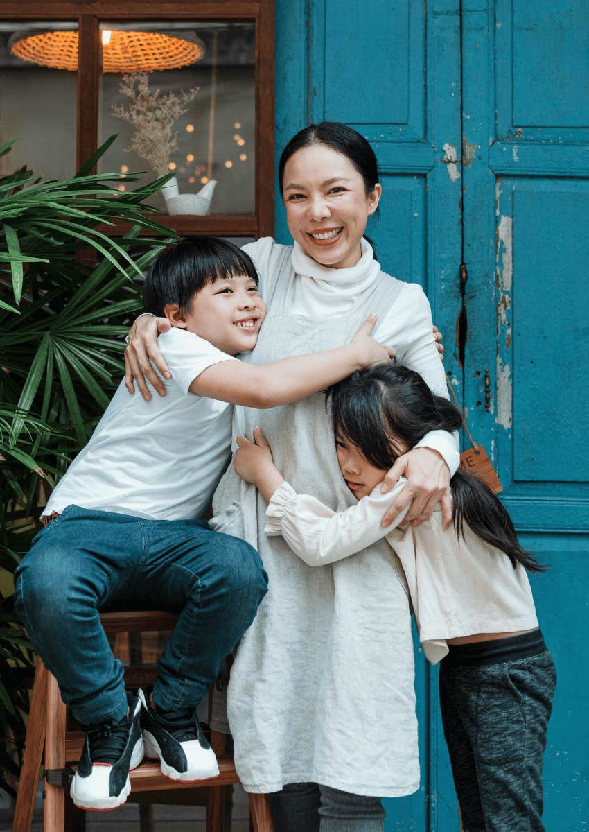 smiling woman hugging her children close
