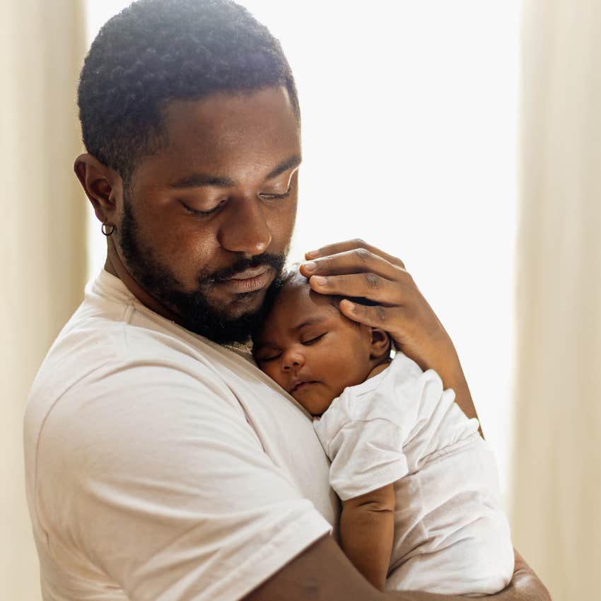 dad holding his newborn realizing he doesn't want more kids