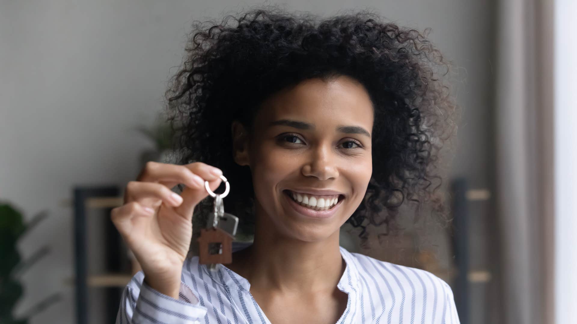 happy person holding keys showing they could afford it