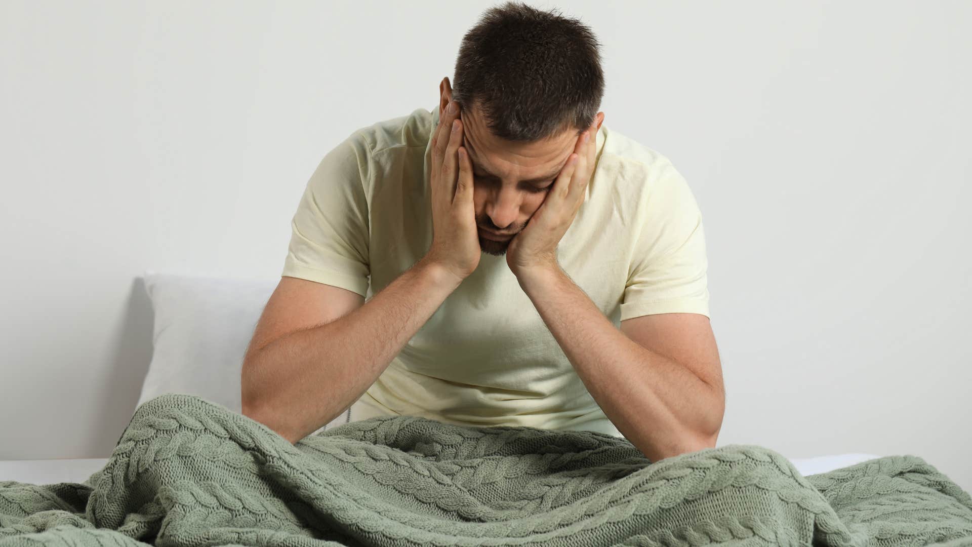 Man who's carrying negative energy from others at home in bed.