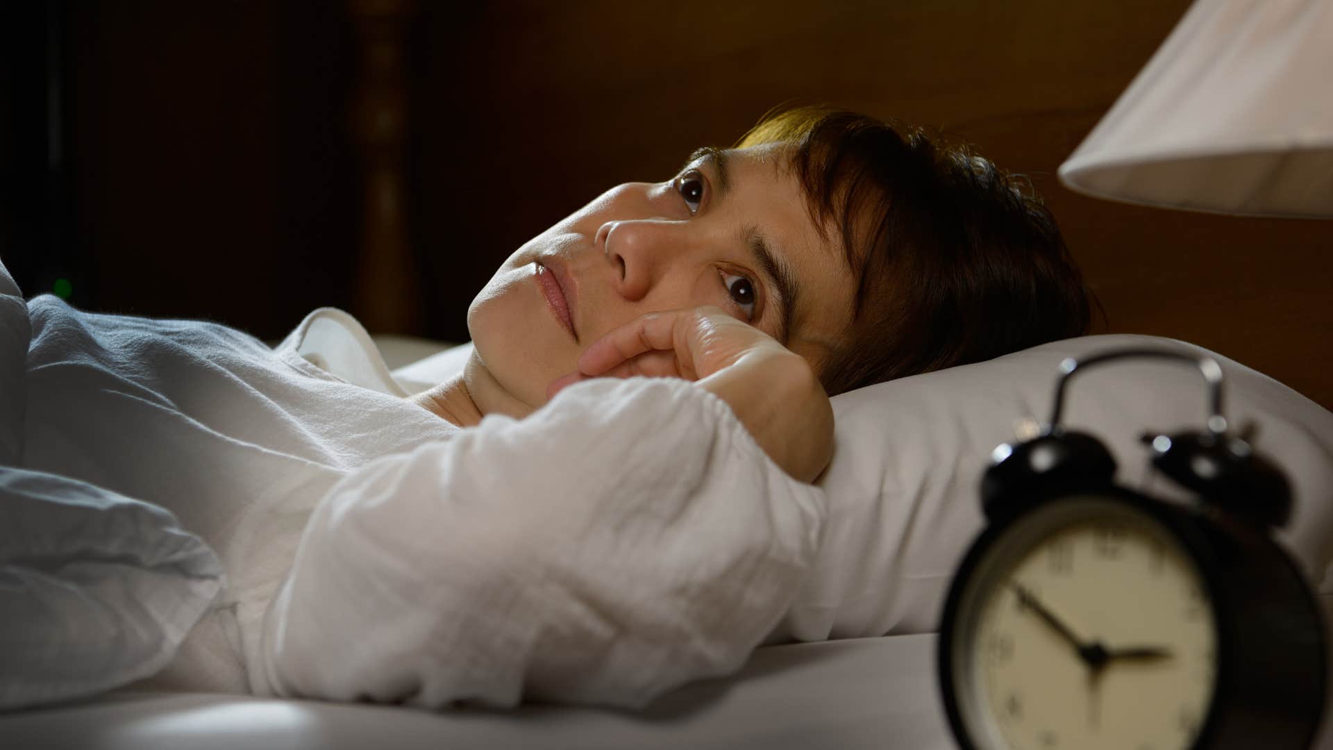 Woman who's an overthinker lying awake in bed.