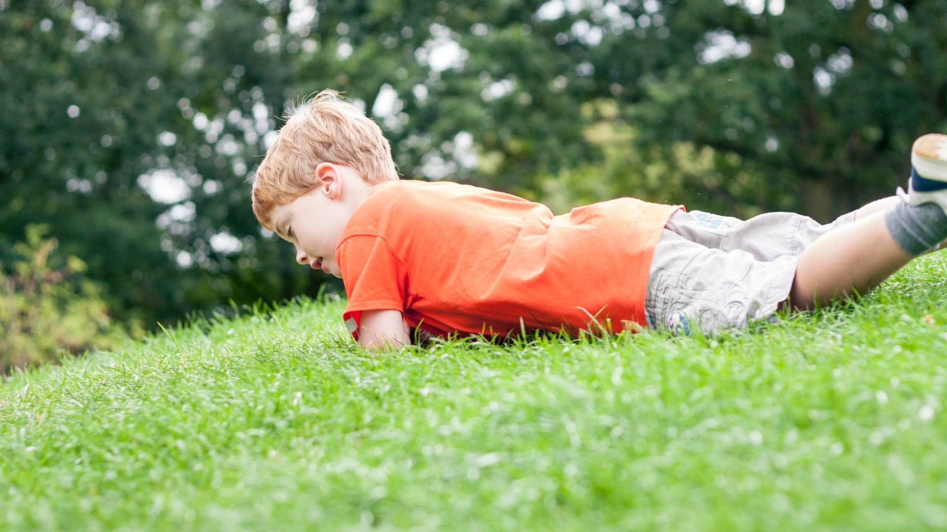 little boy rolling down hill