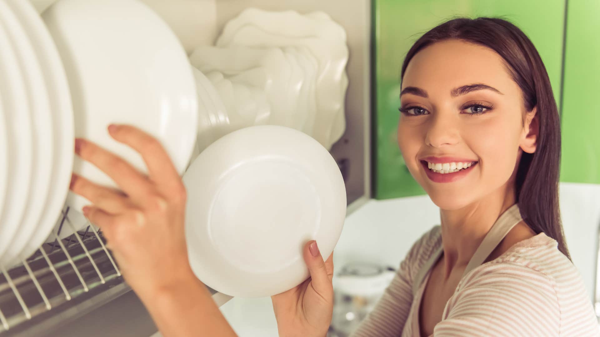 woman taking out plates from the cabinet