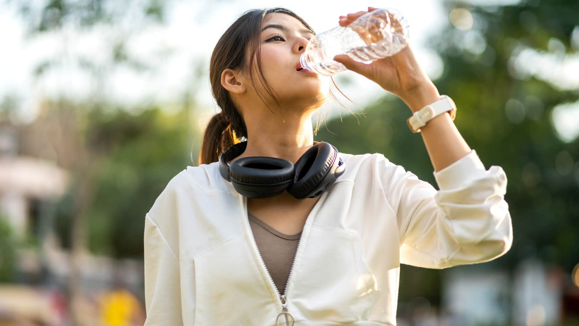 woman drinking bottled water outside