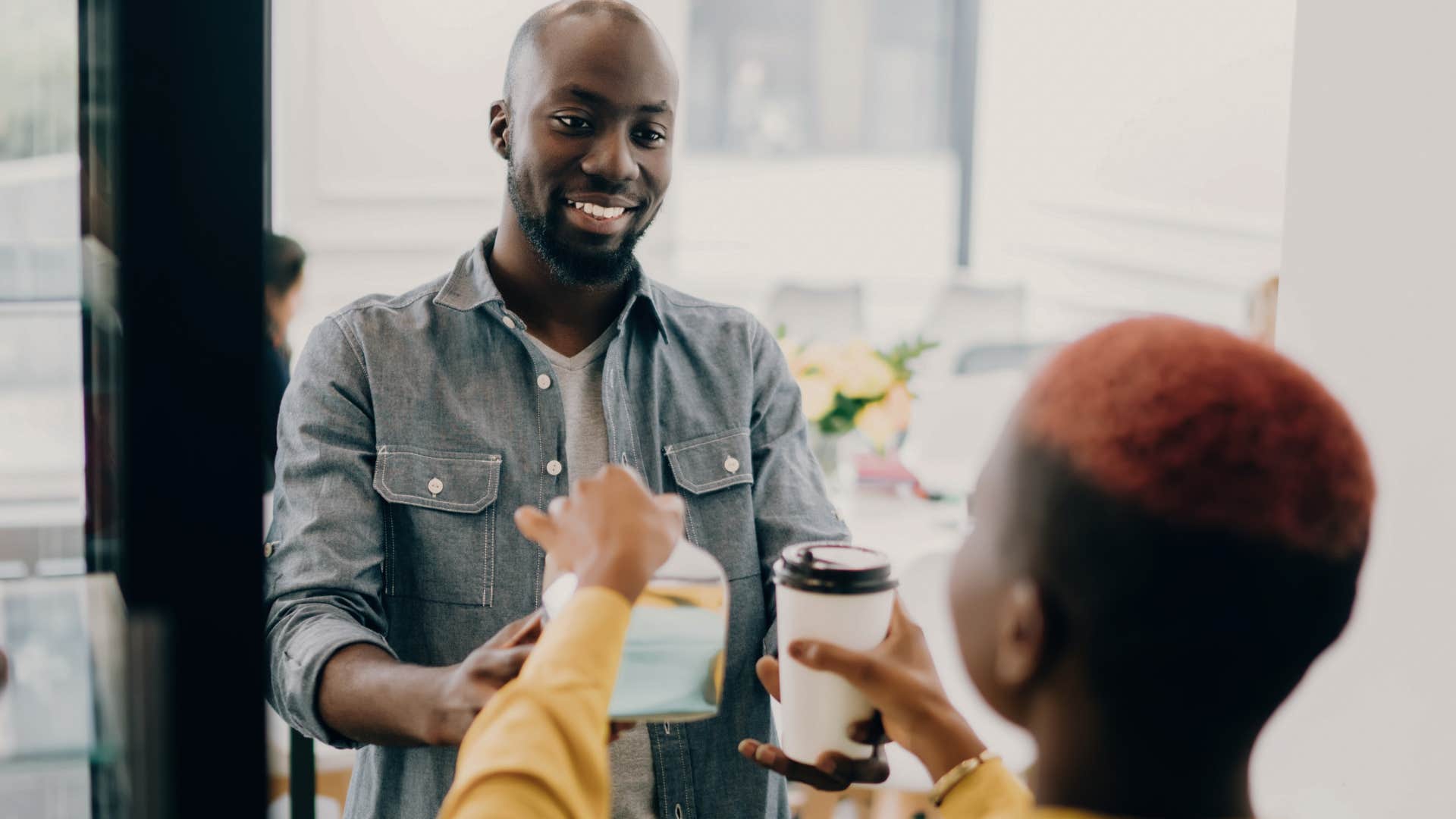 man taking a daily coffee shop trip picking up his order