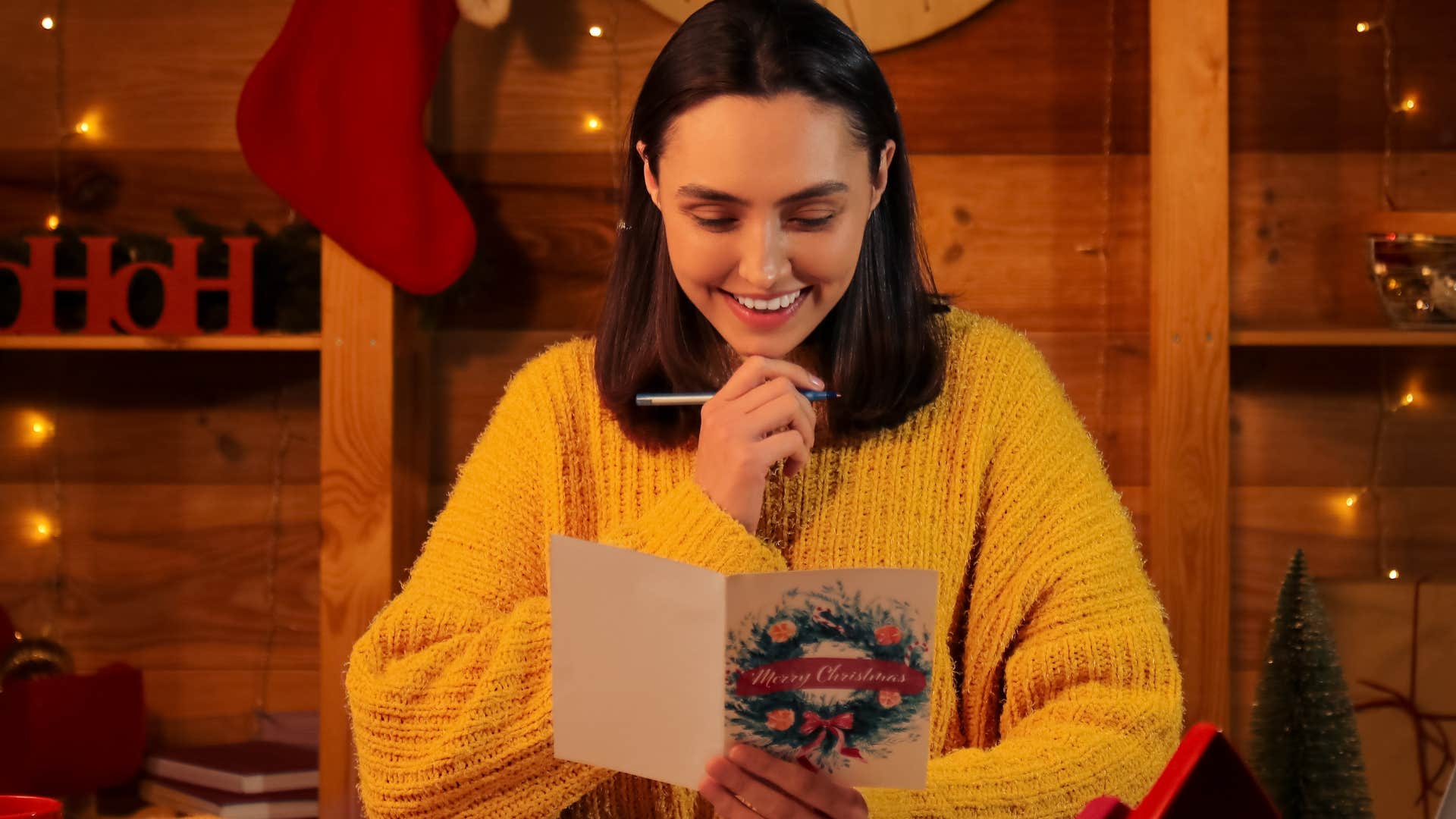 woman writing greeting card during the holidays