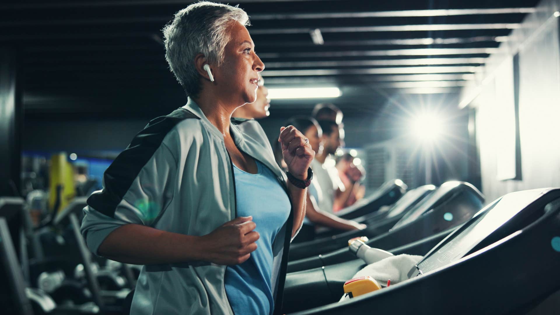 woman with gym membership running on a treadmill