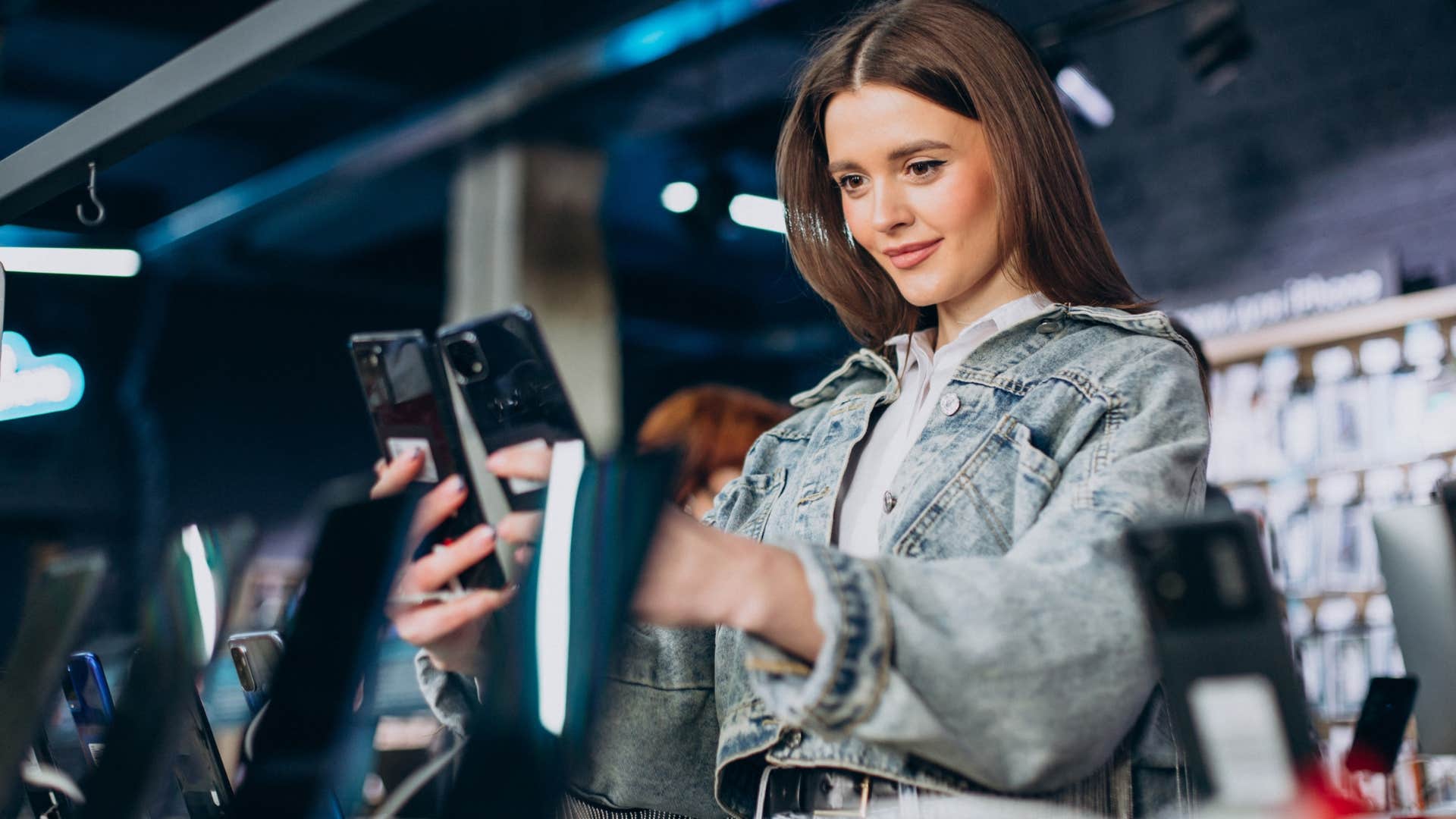 woman looking at tech upgrades at electronics store