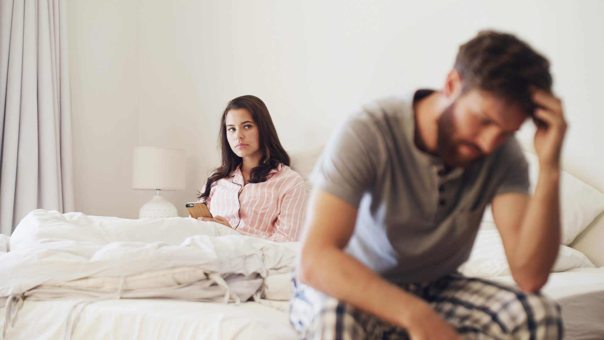woman sitting in bed holding grudge against partner 
