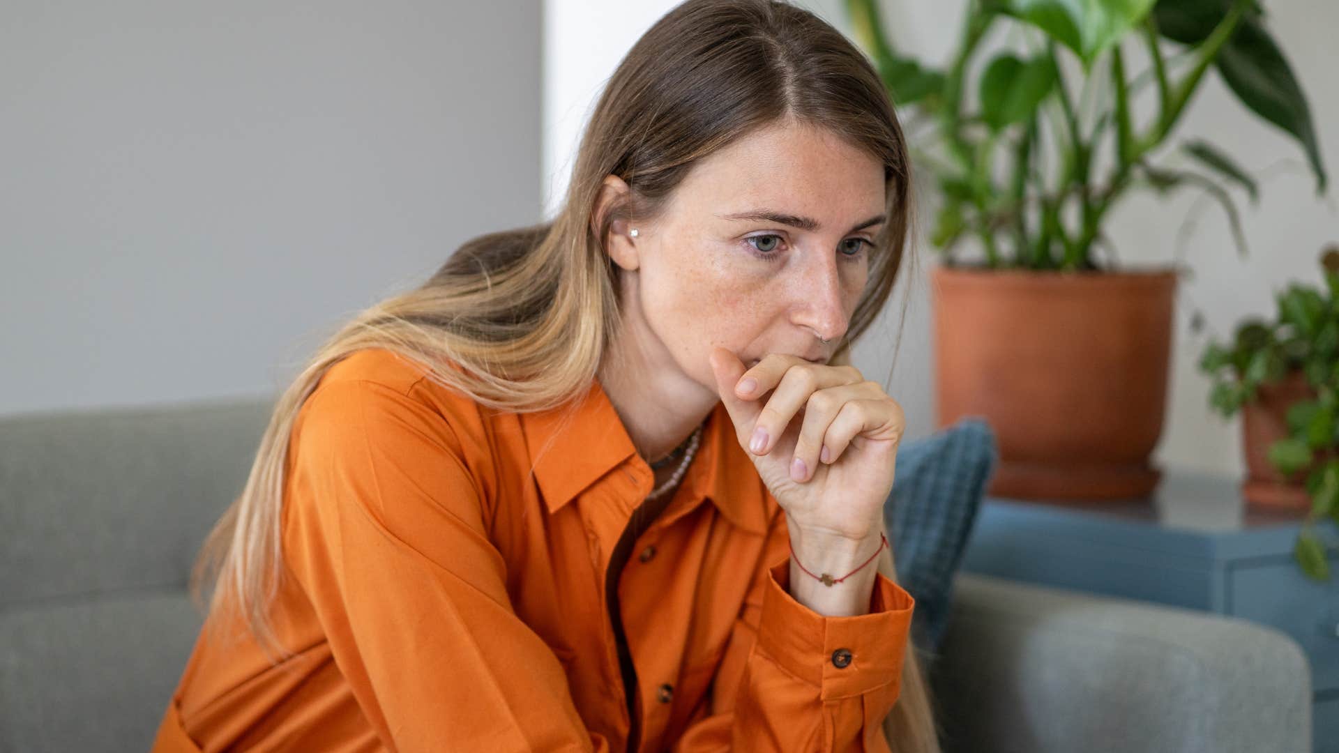 woman sitting on couch thinking of old conversations