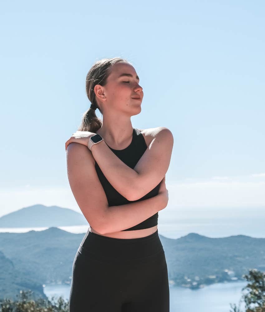 Peaceful person in nature hugs self showing time heals