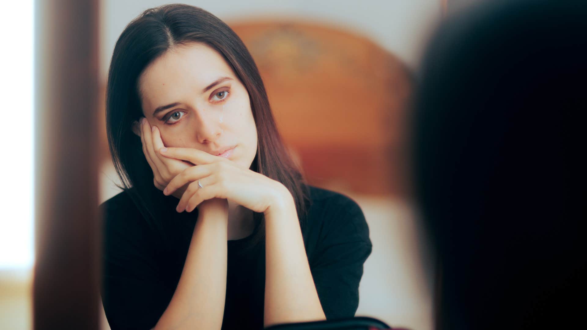 woman in black shirt is the constant comparer as she stares at the mirror