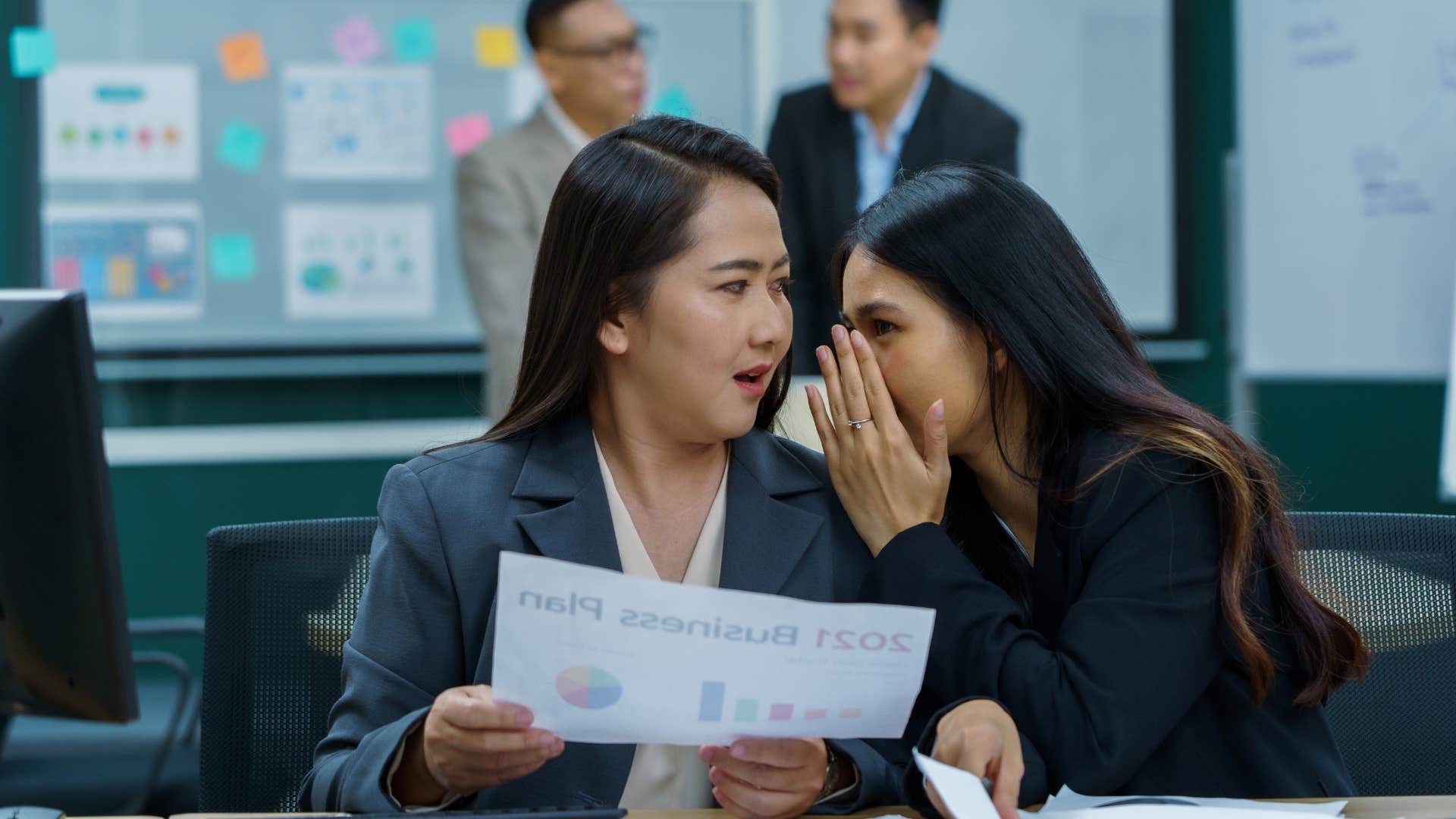 coworkers talking negatively as girl gossiping is the gossip distributor