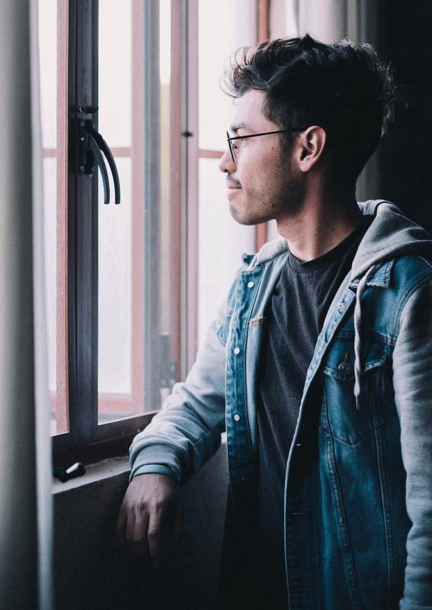 thoughtful young looking out of window realizing something