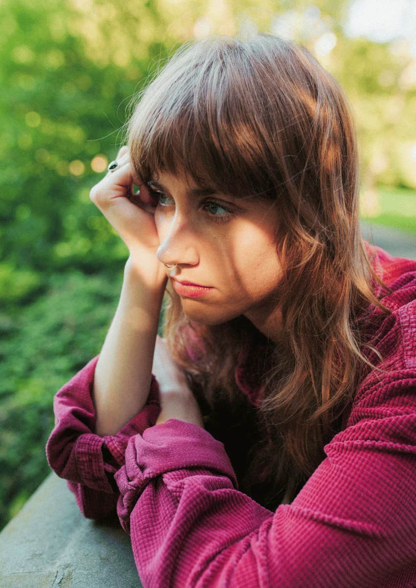 thoughtful young woman sitting outside