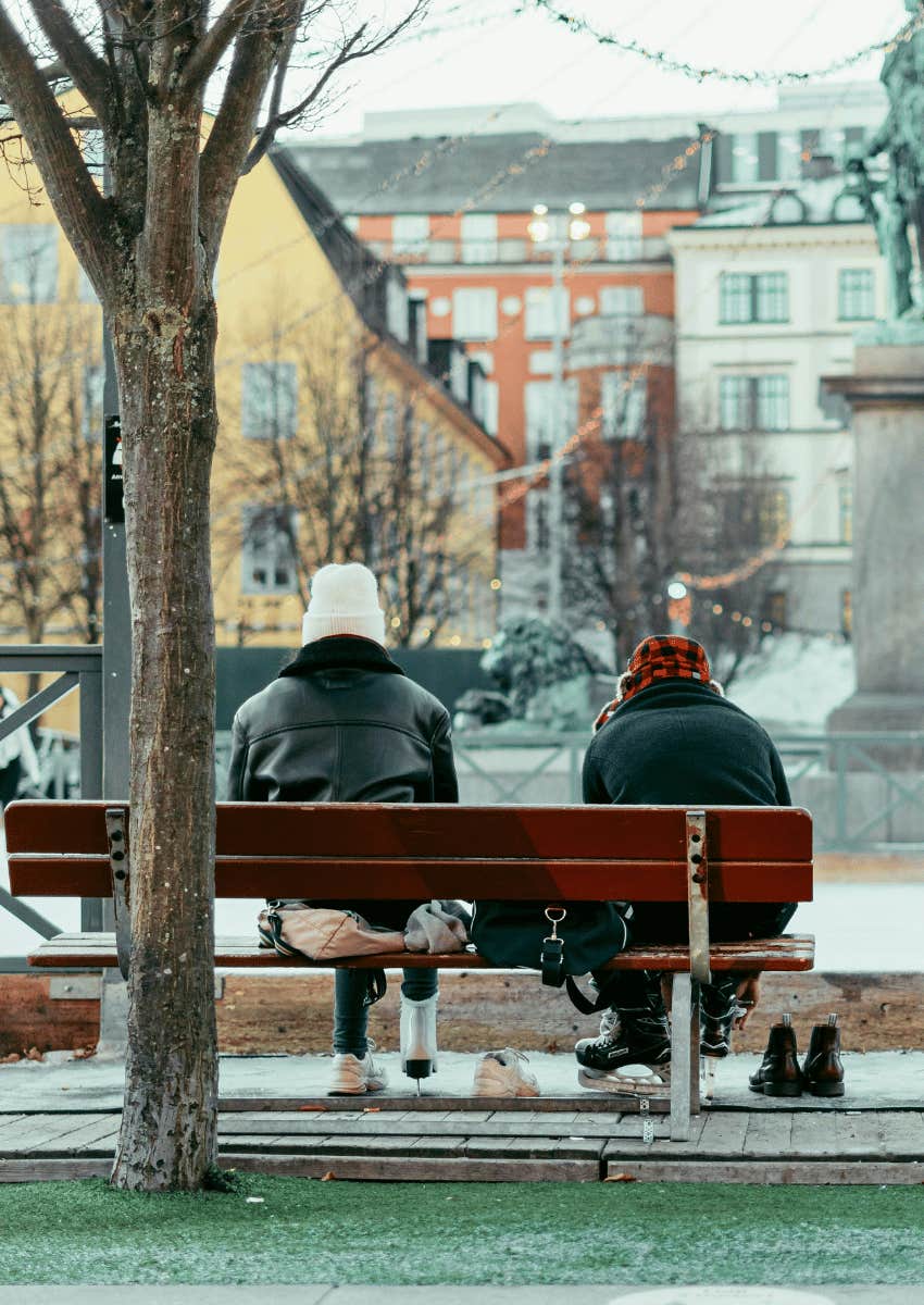 two people sitting on park bench