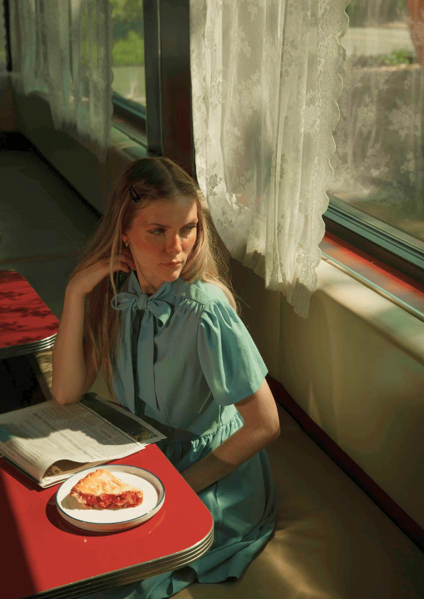 woman eating alone sitting by a window