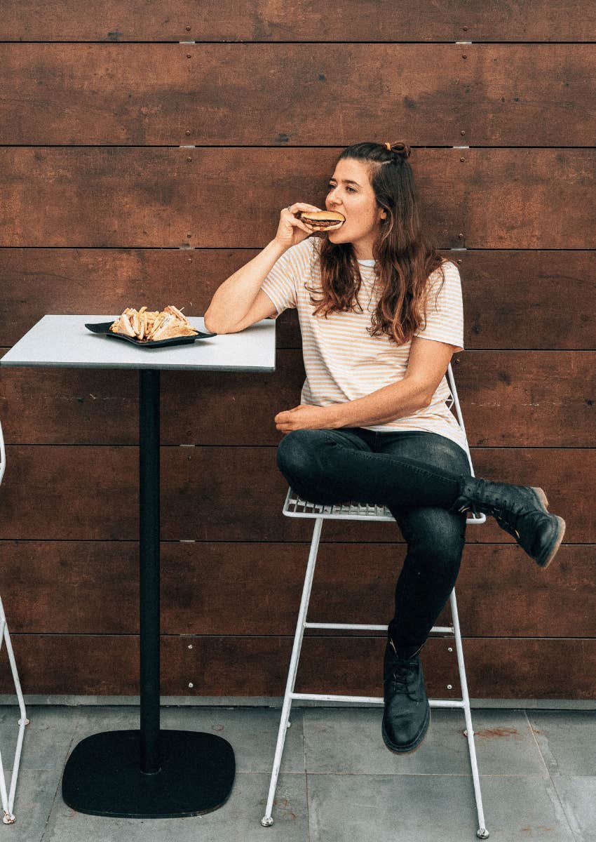 young woman eating outdoors alone