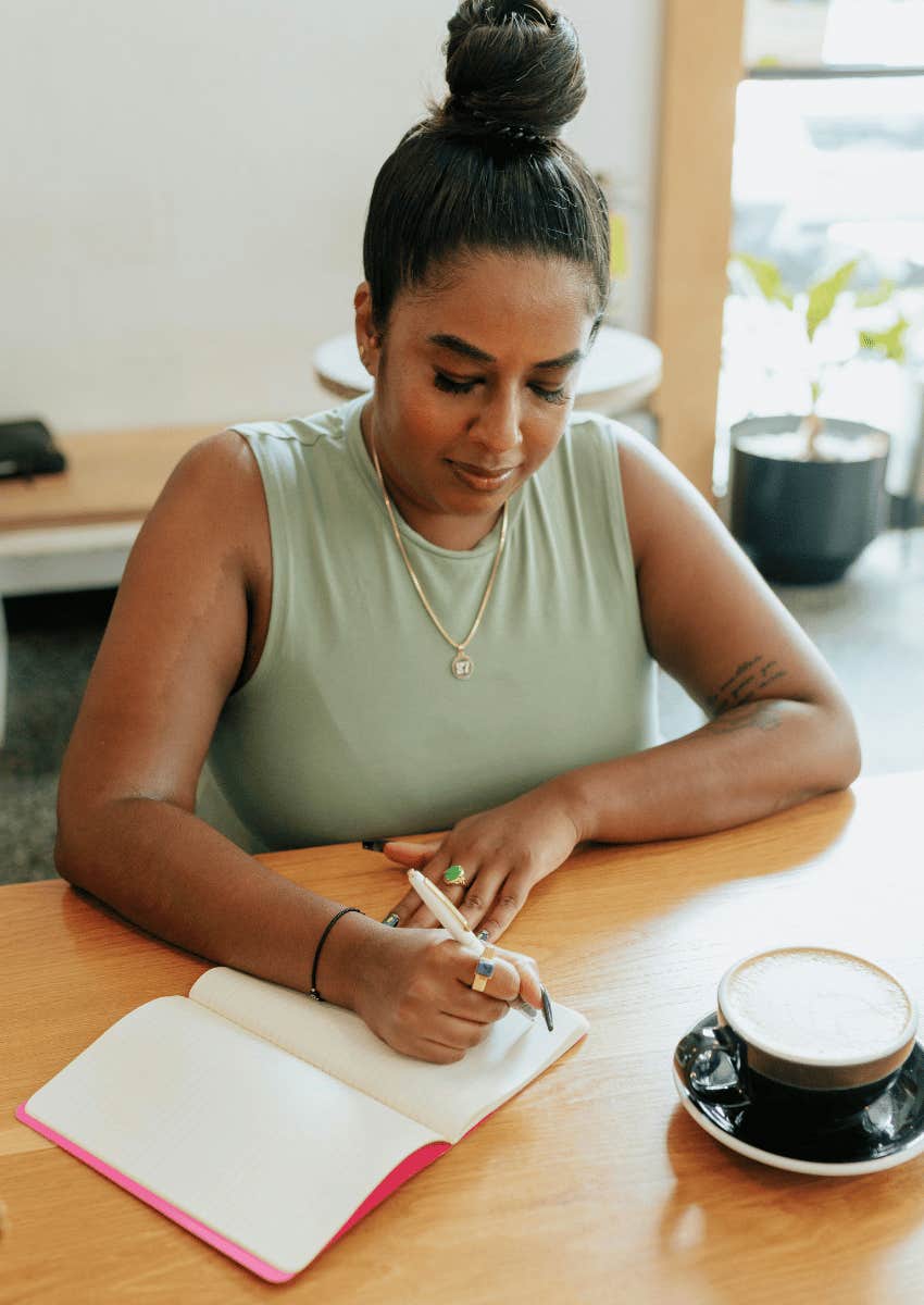 woman journaling about her moment of clarity at dining room table