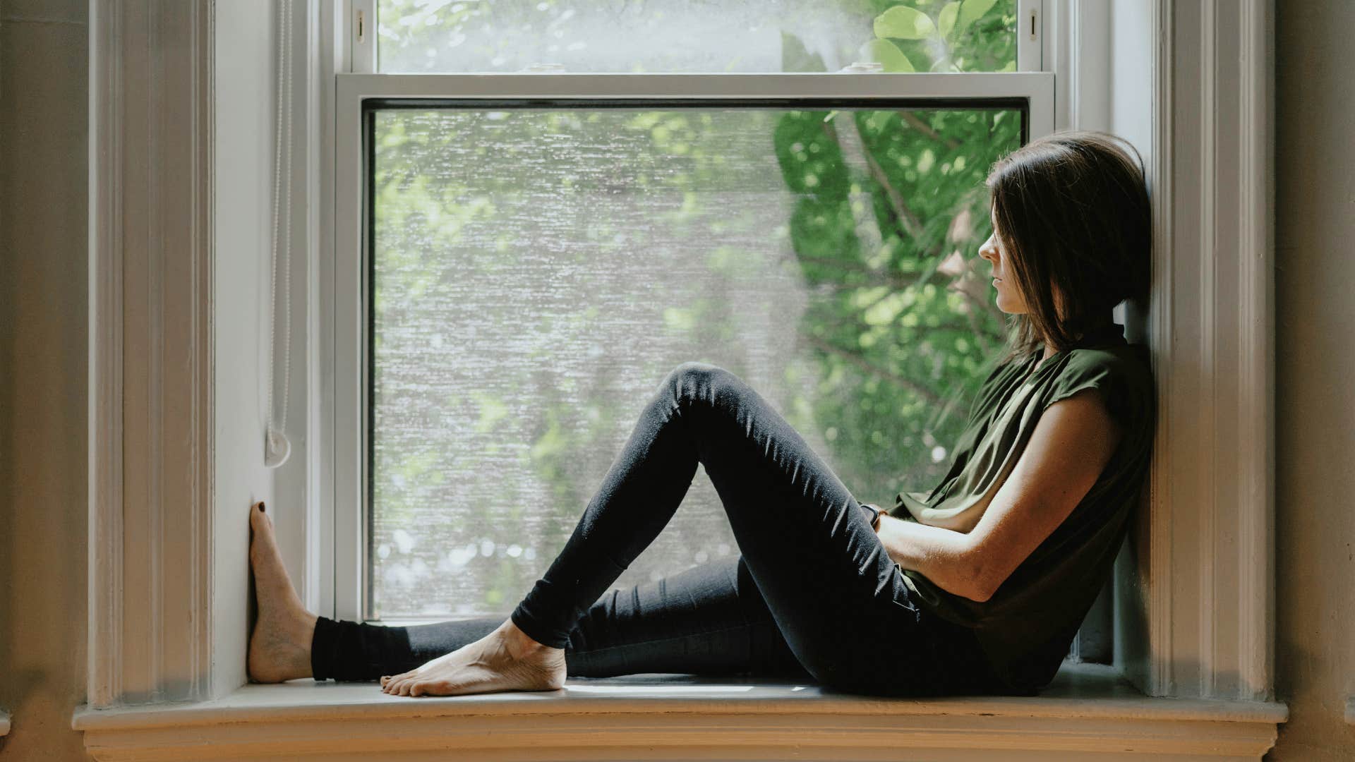 woman sitting alone on window feeling off might be more than sadness