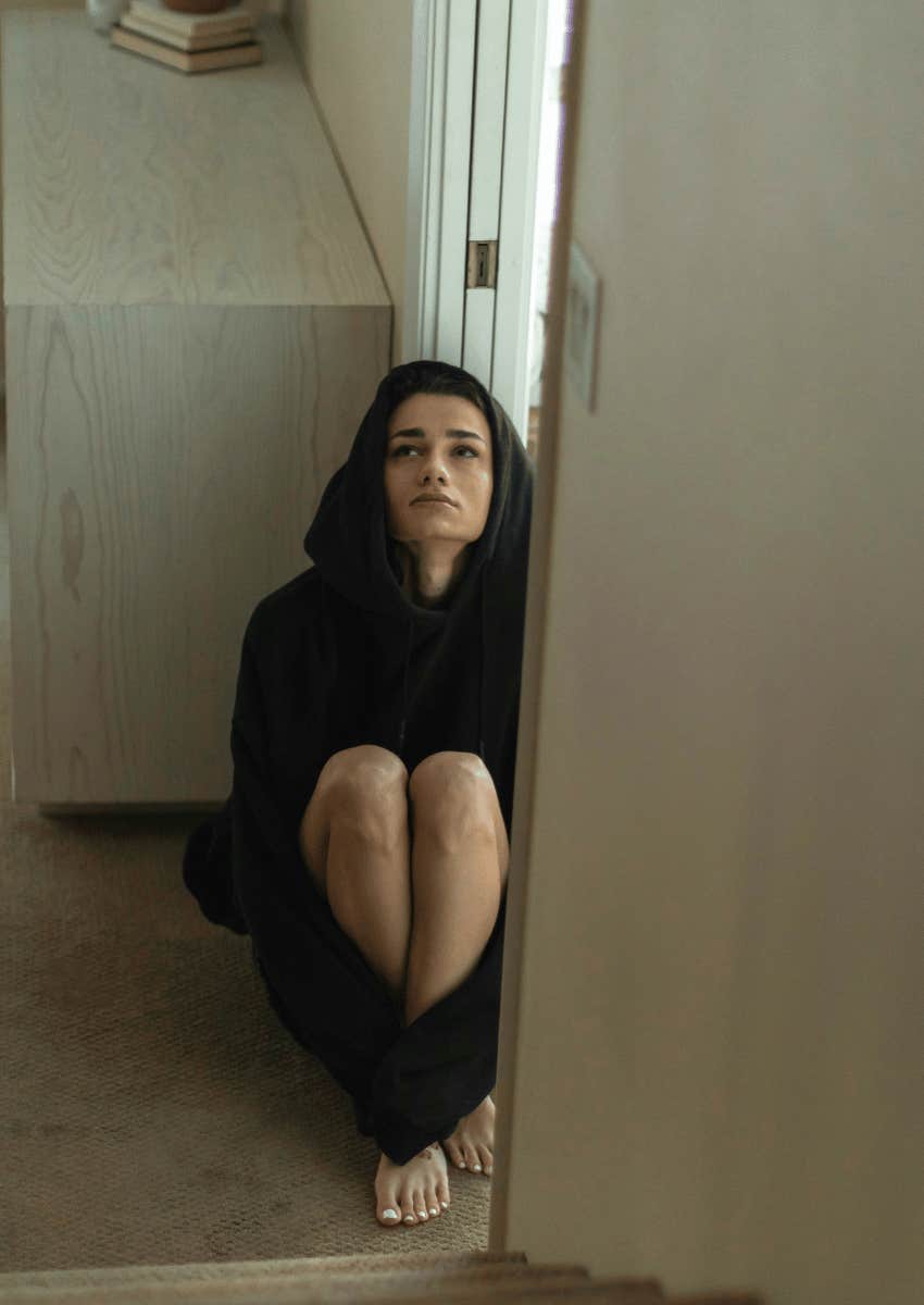 woman sitting on the floor alone in an empty room