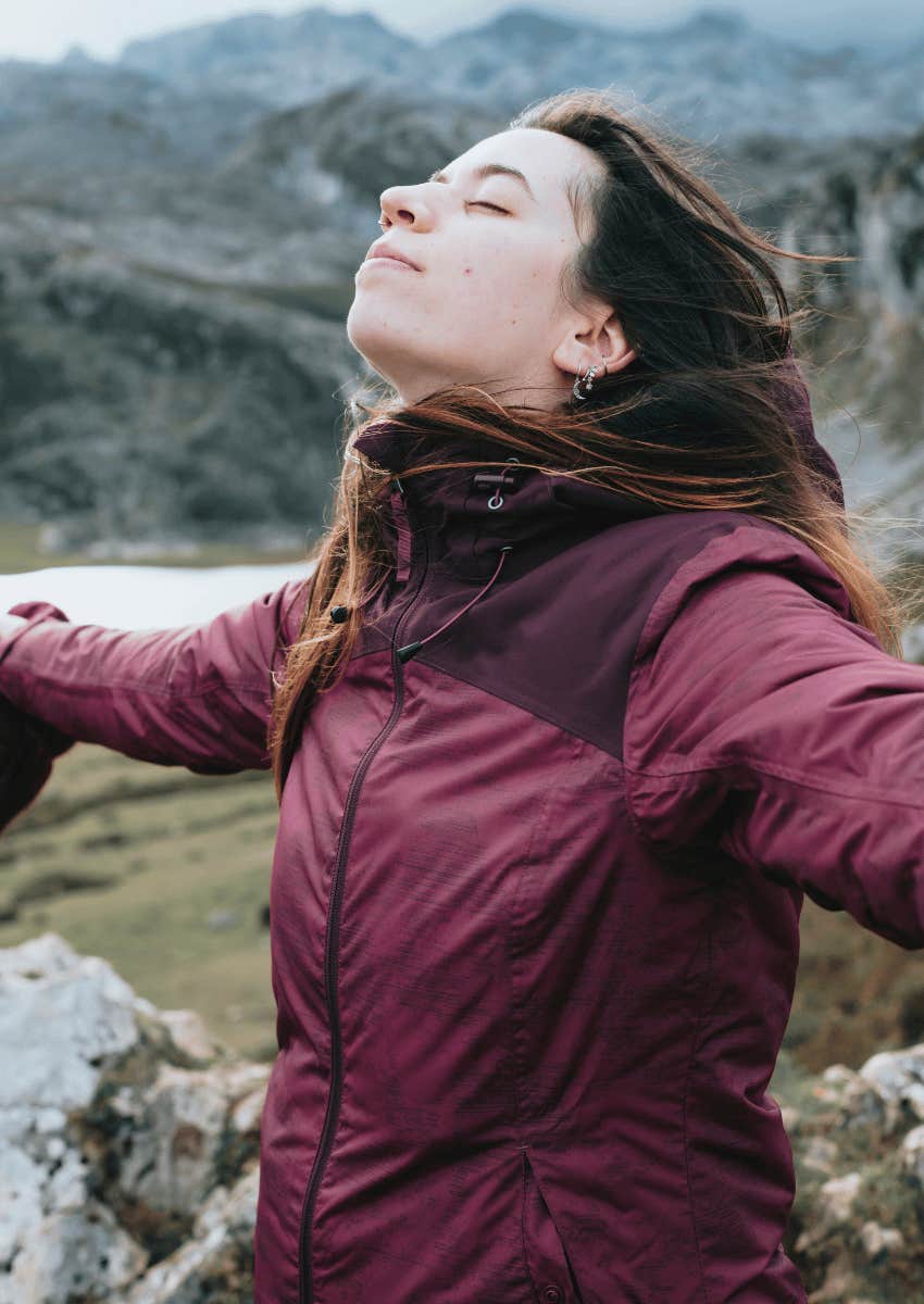 woman standing outside with her arms open