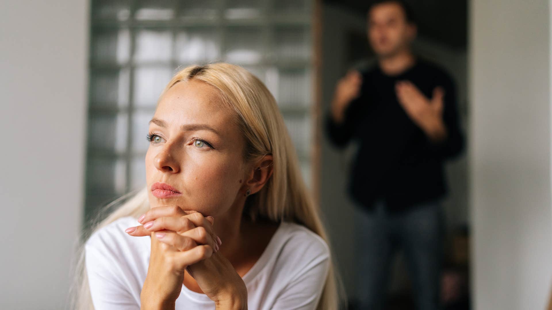 woman in white shirt begins ignoring her loved one's as man tries talking to her