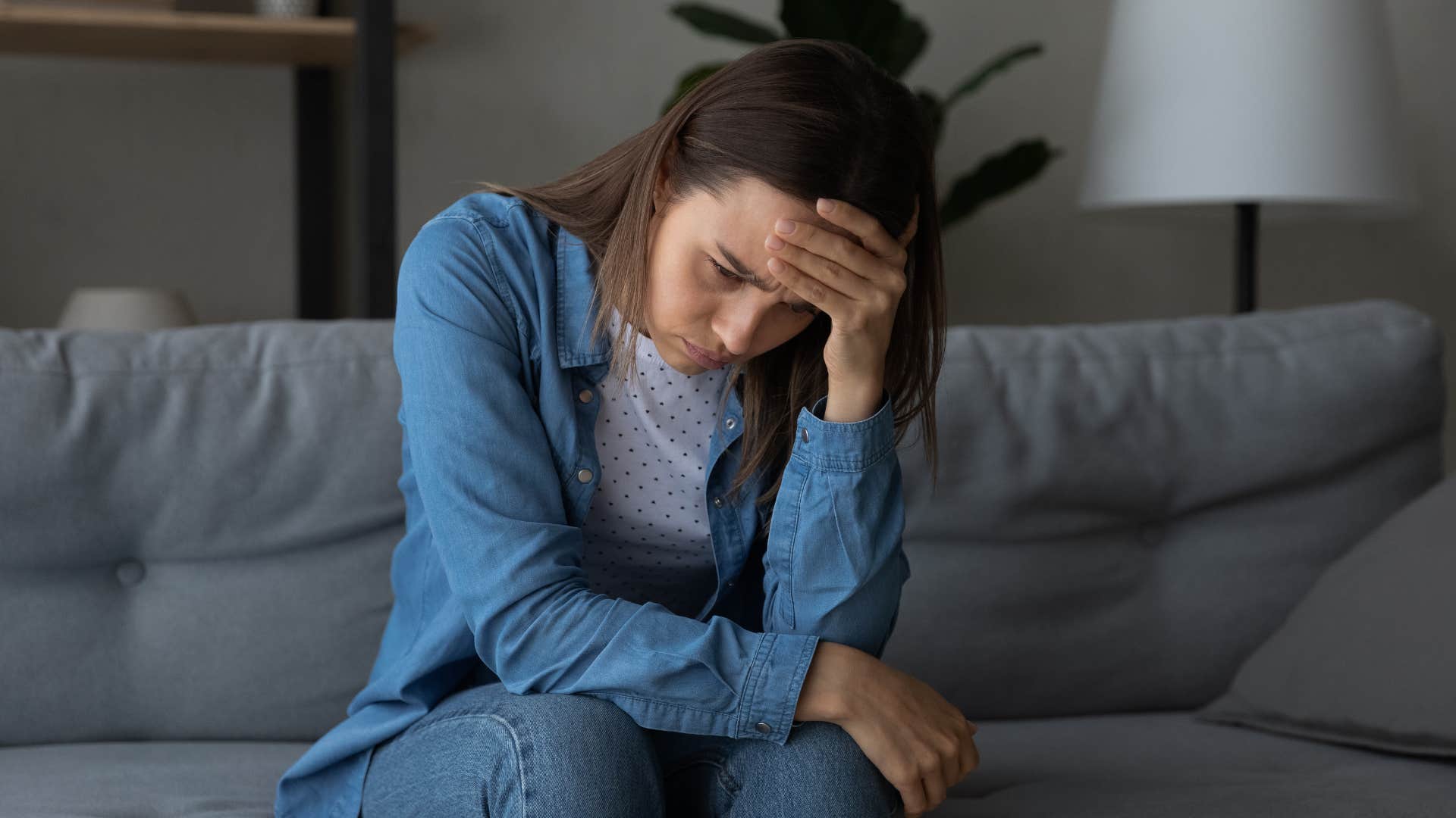 woman in blue jacket thinking deeply as they're highly distrustful