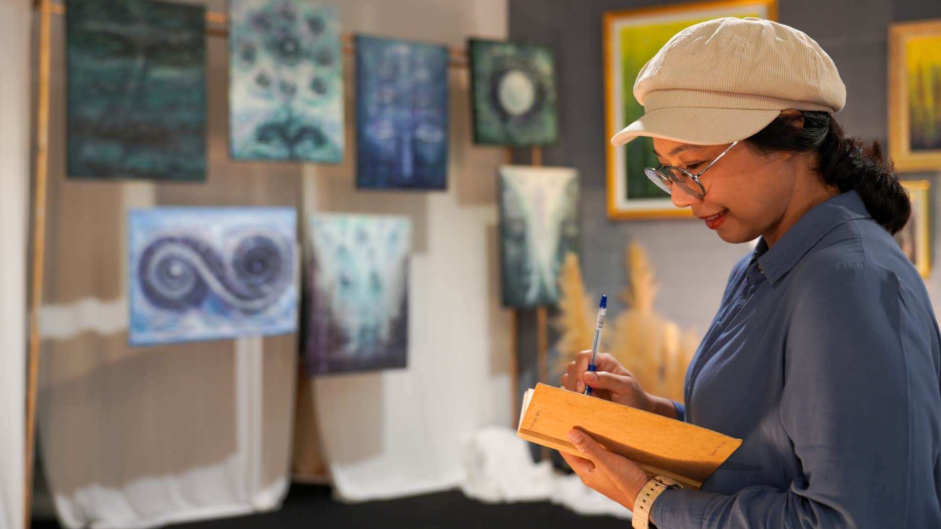 woman at art gallery being highly observant as she writes something down