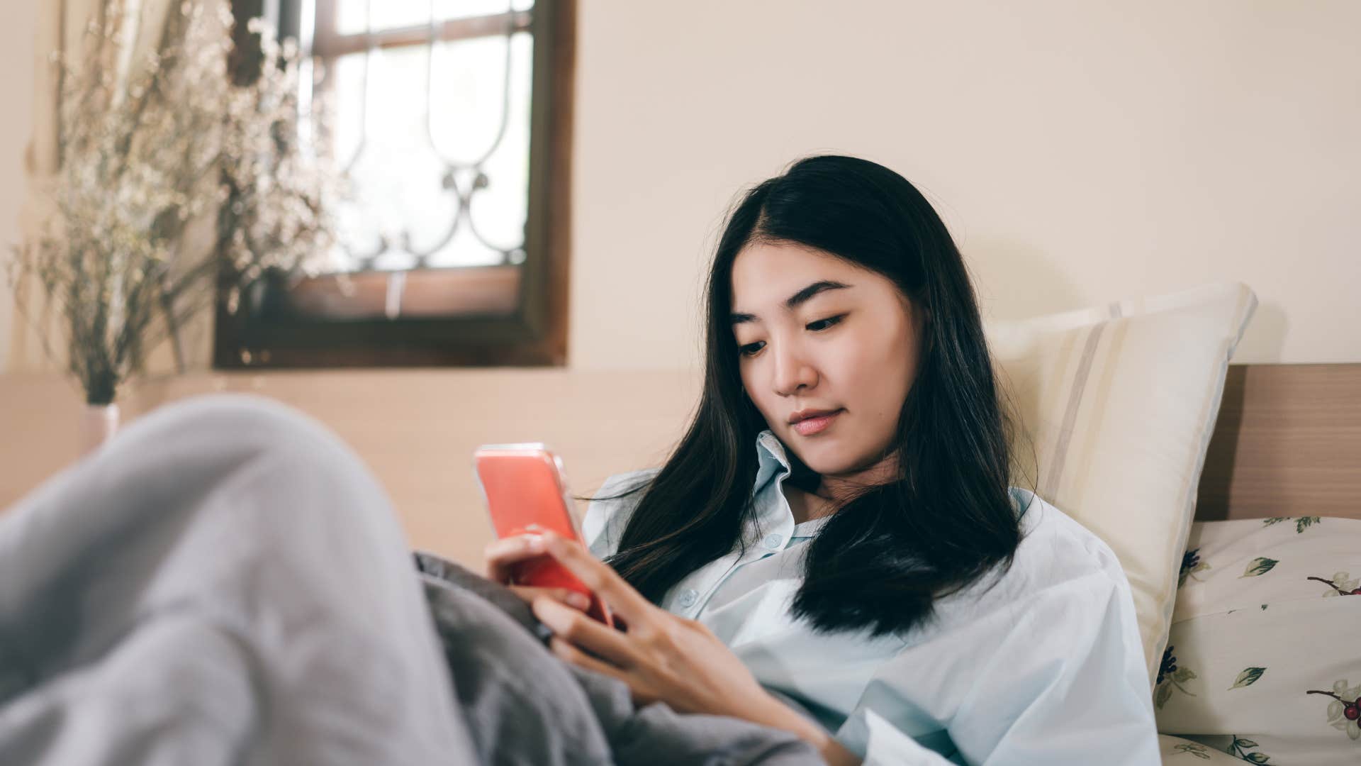 woman who watches videos on her phone before bed because she is driven by habit