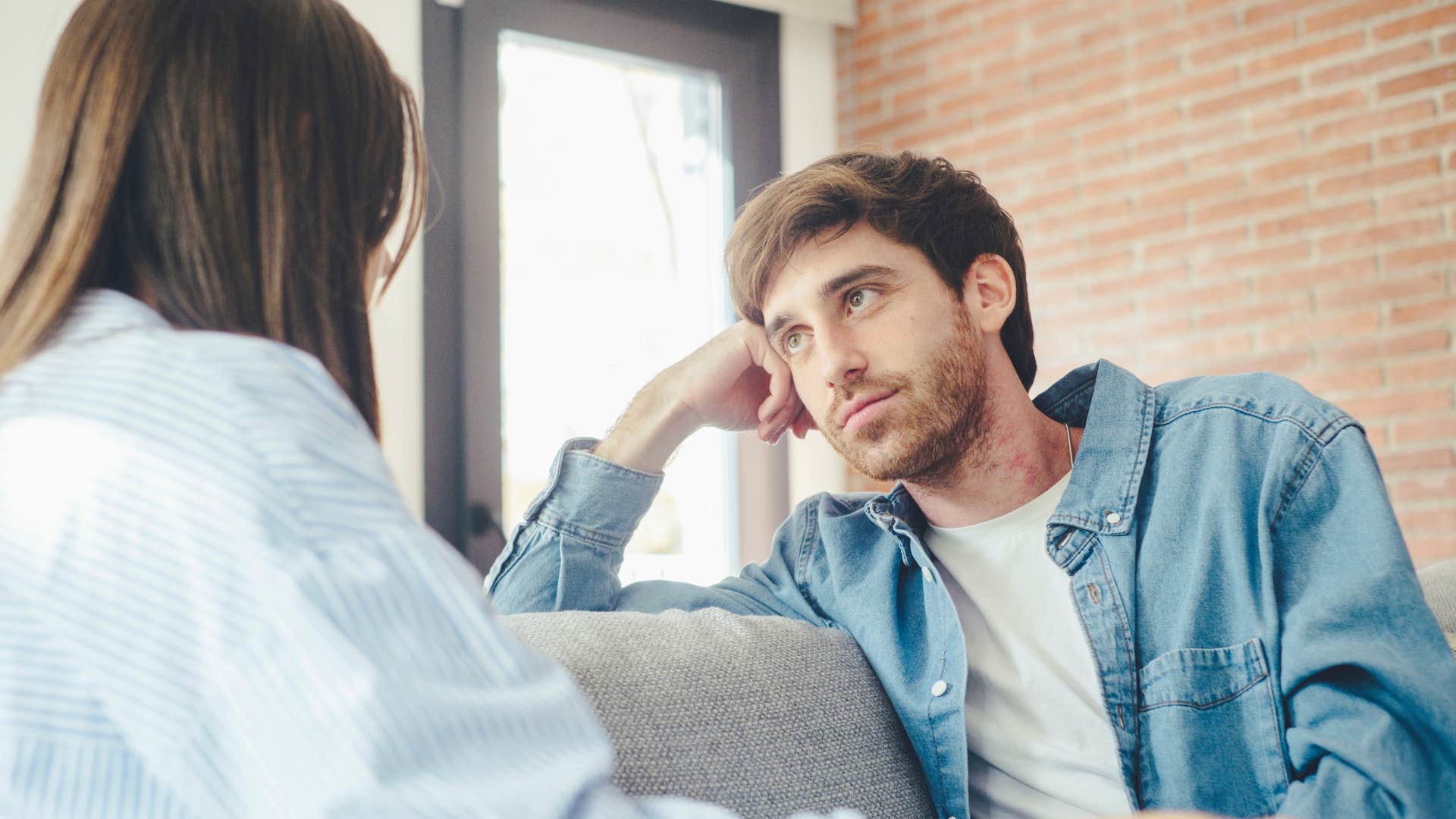 woman telling man i'm looking for something meaningful talking on couch