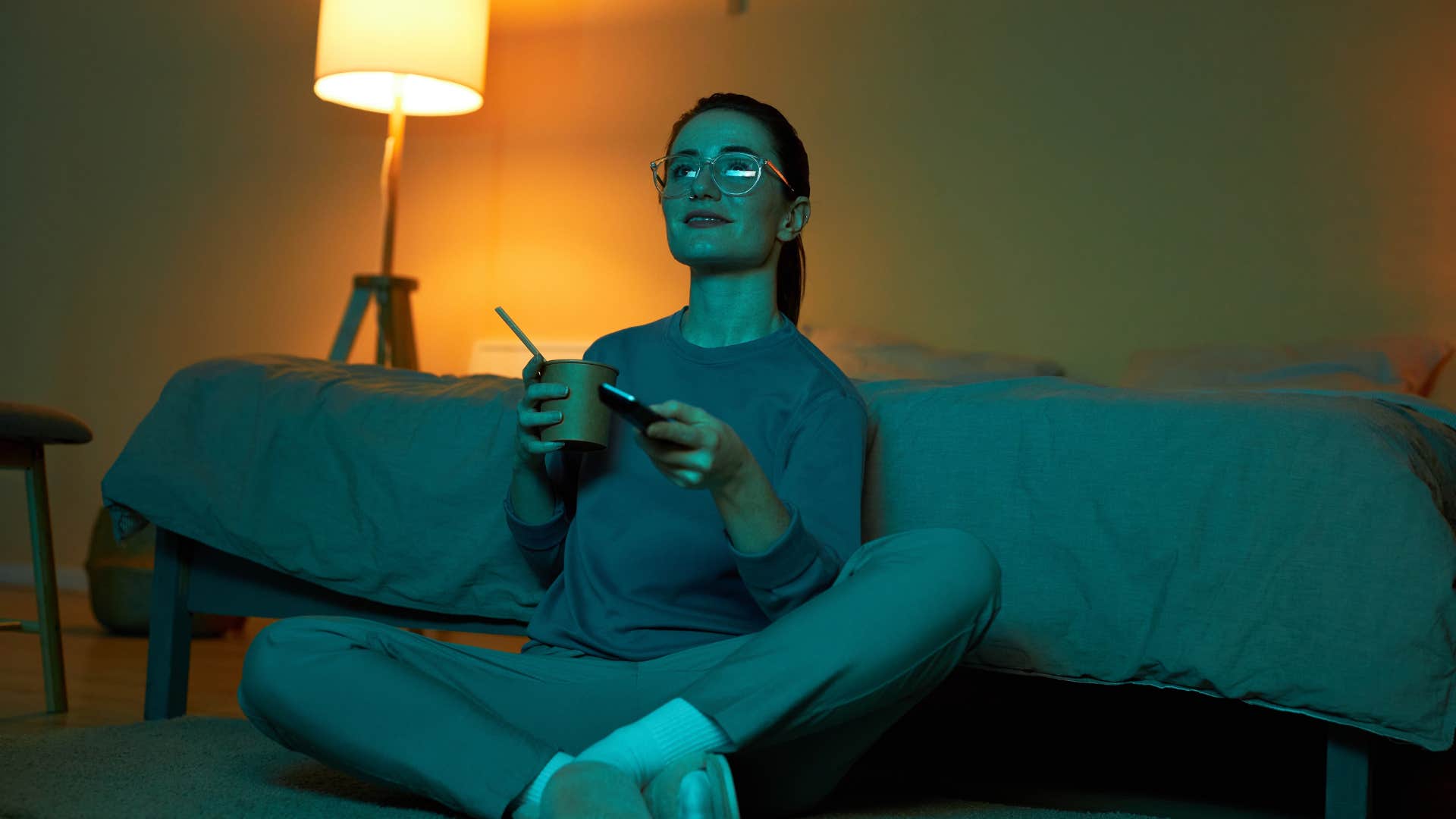 woman who cares about personal comfort eating on the couch watching tv