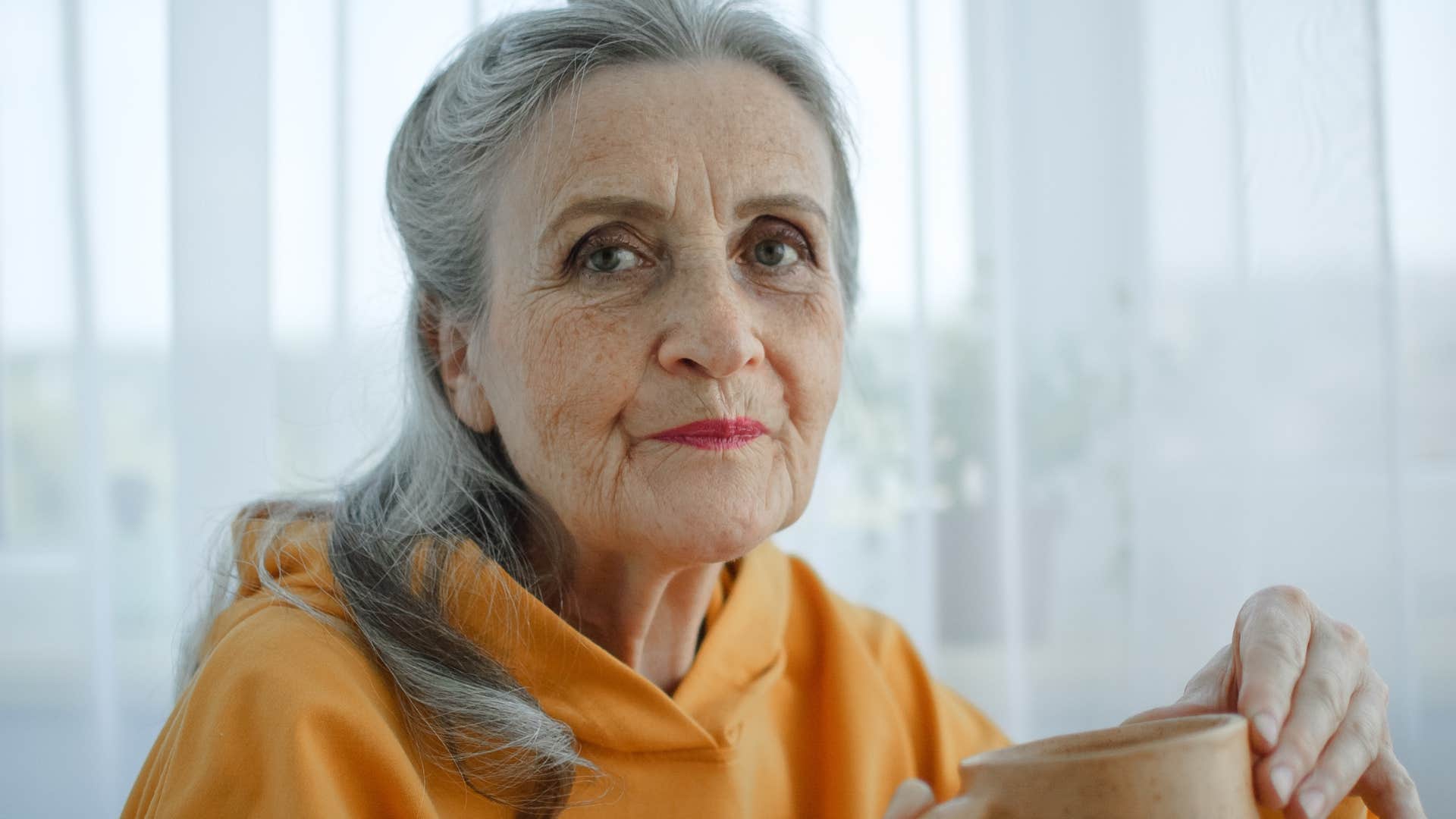 Authentic and unconventional woman sipping coffee at home.