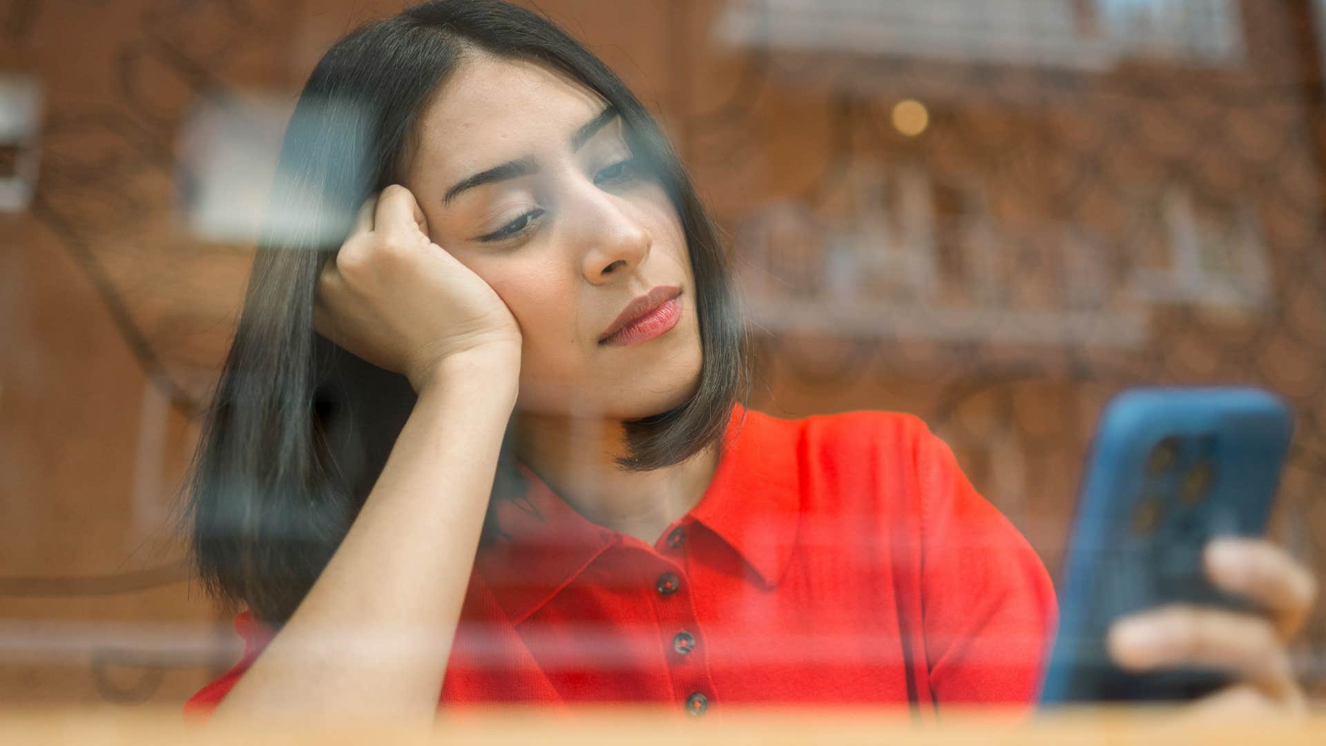 Woman struggling with boredom on her phone.