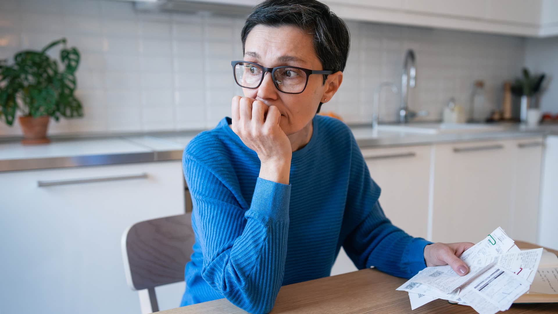 Woman struggling with financial constraints at home.