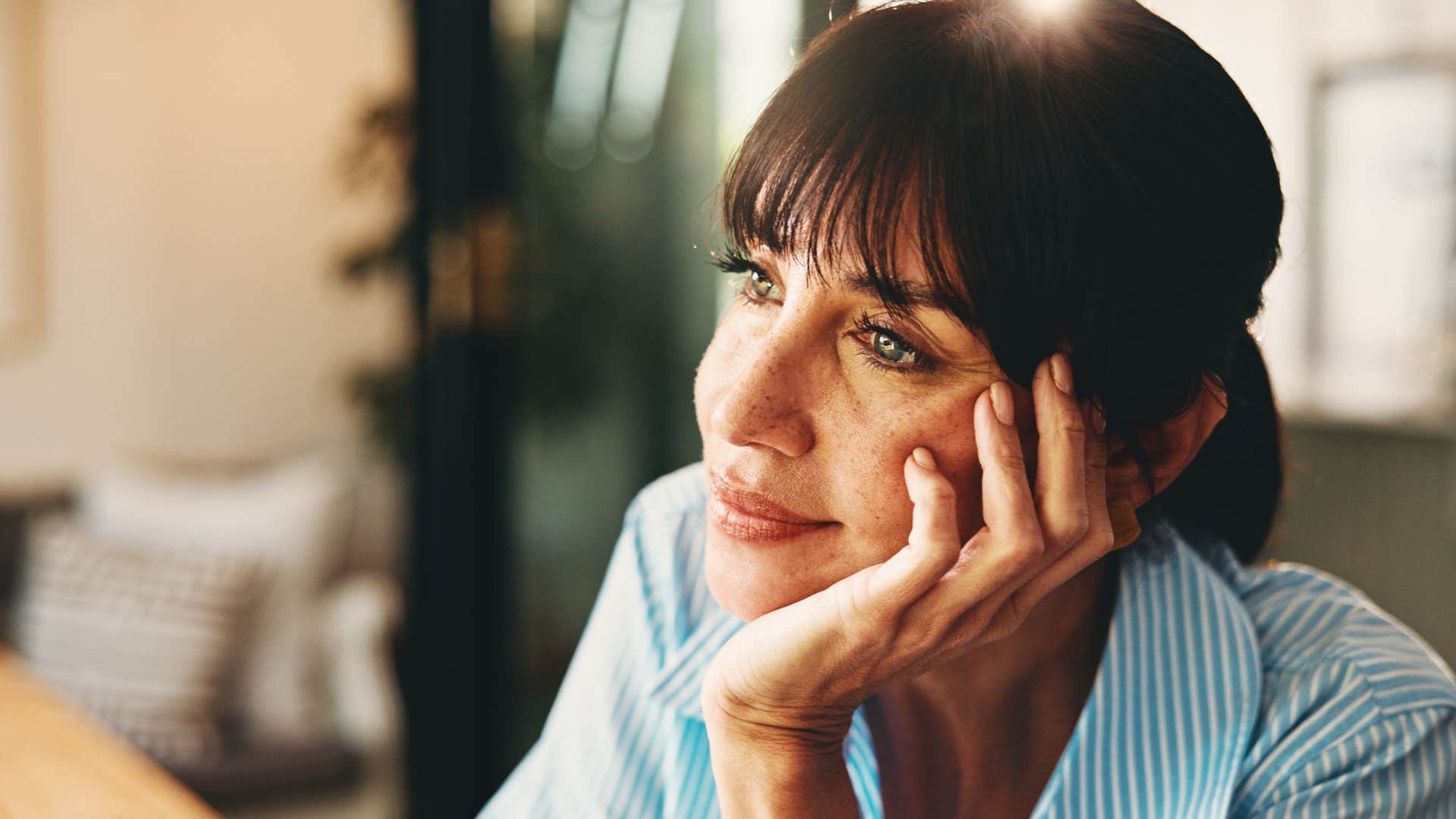 wildly self-reflective woman sitting at home enjoying being alone